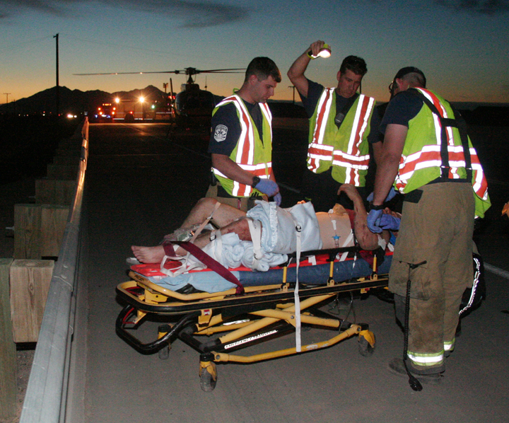 Paramedics treat patient with helicopter in the background